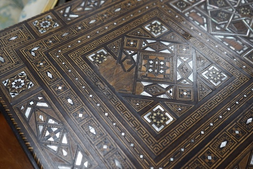 A 19th century Damascus mother of pearl, bone, and marquetry inlaid folding games table, with card, backgammon and chess surfaces, width 94cm, depth 47cm, height 85cm